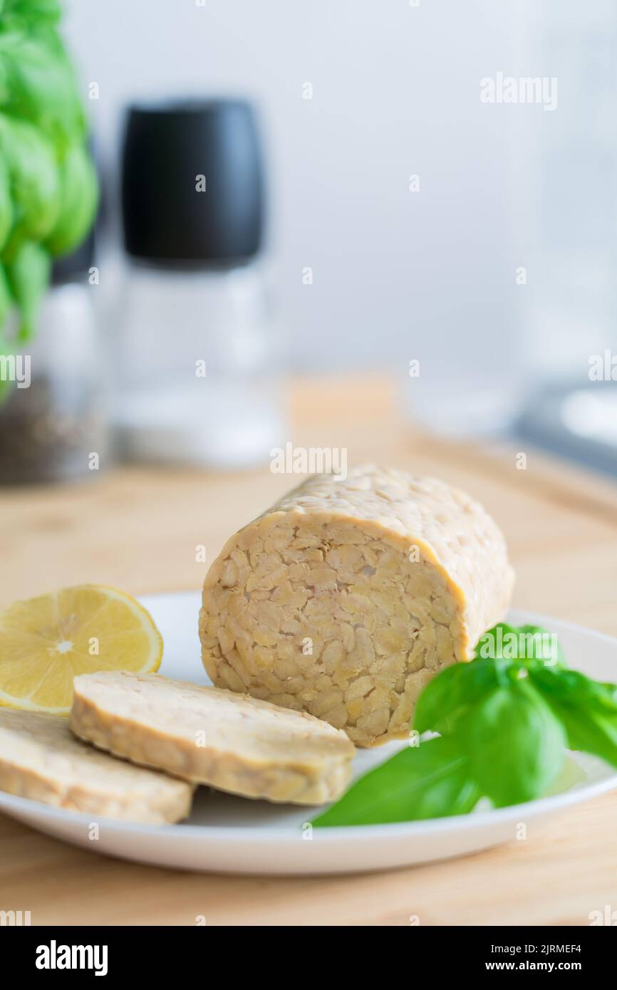 Raw Tempeh or Tempe, made of fermented soybean seeds on kitchen table