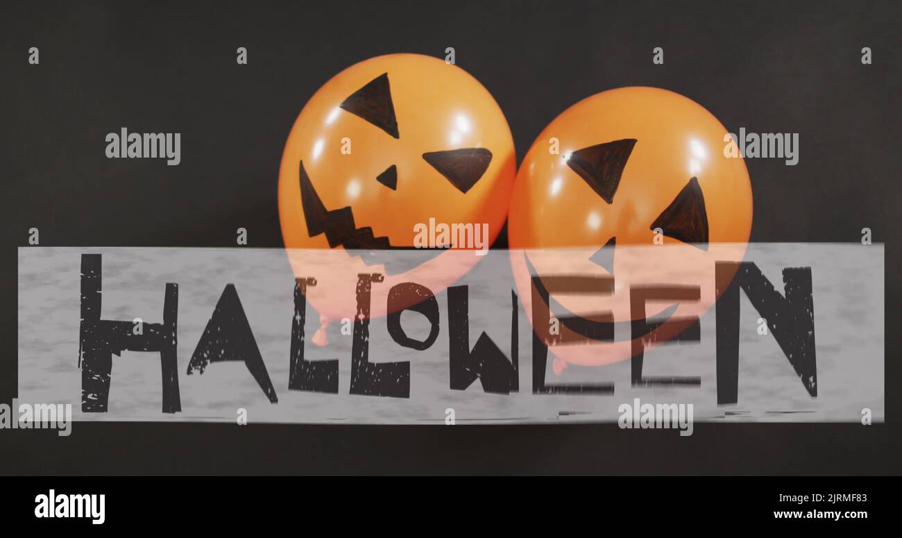 Happy halloween text banner over two halloween pumpkin printed balloons against black background Stock Photo