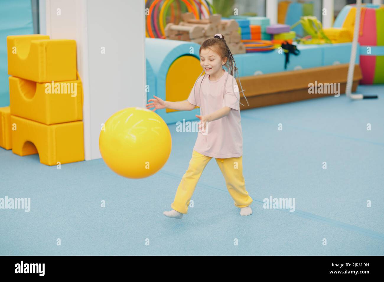 Kids doing exercises with big ball in gym at kindergarten or elementary