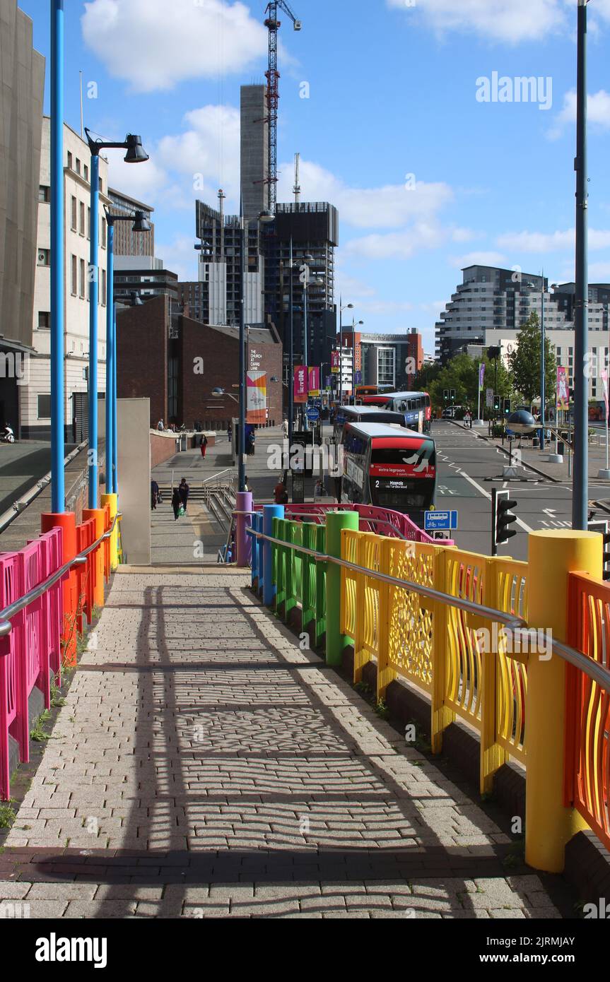 Multicolored railings on pedestrian walkway looking towards area outside Moor Street station down ramp from New Street area in Birmingham city centre. Stock Photo