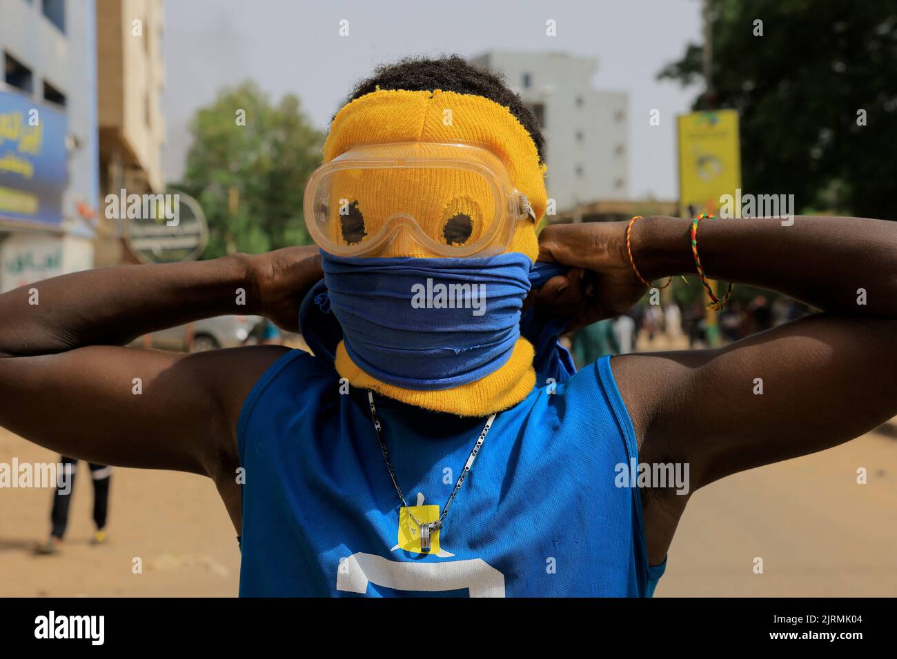 A person wears a mask, as protesters march through the capital Khartoum during a rally against military rule following the last coup, in Khartoum, Sudan August 25, 2022. REUTERS/Mohamed Nureldin Abdallah Stock Photo