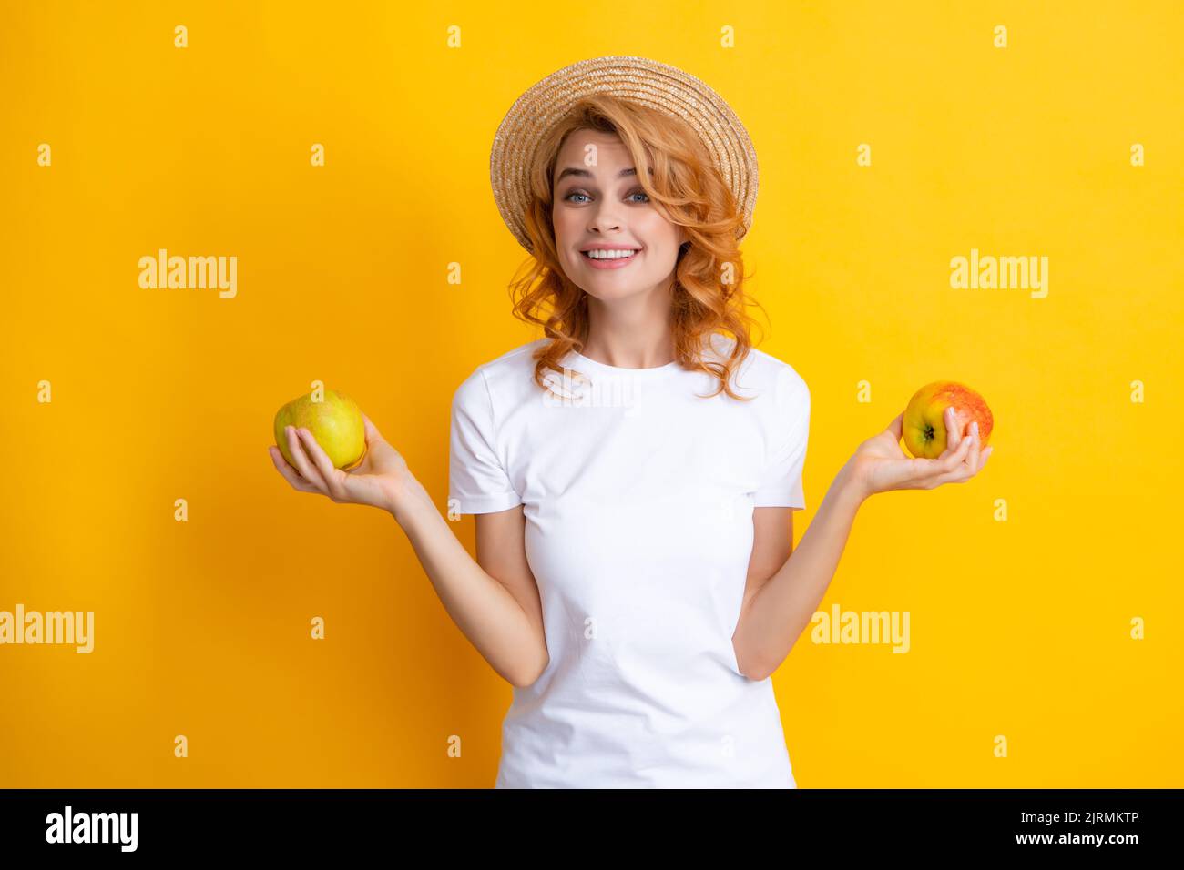 Beautiful caucasian woman holding apple, smiling happy, studio isolated portrait. Stock Photo
