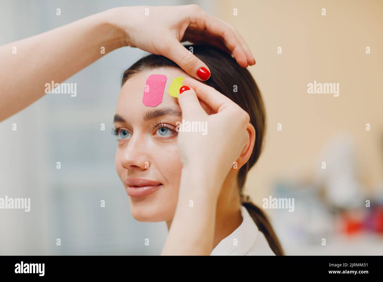 Beautiful woman applying tape lifting treatment procedure on face Stock Photo Alamy