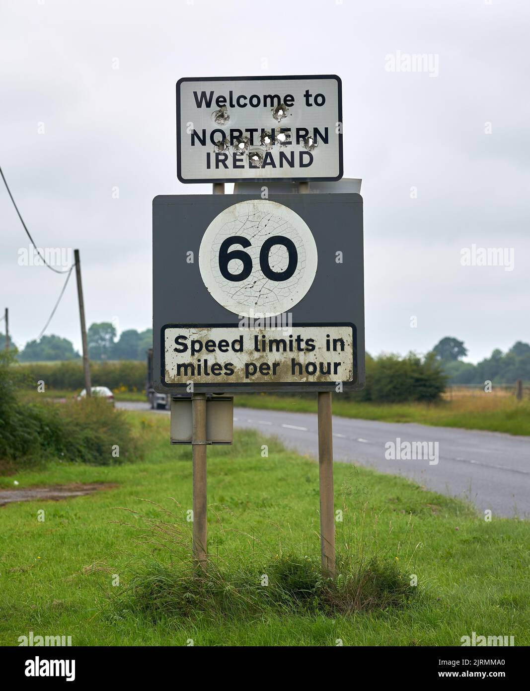 A welcome to Northern Ireland sign riddled with large bullet holes. Stock Photo