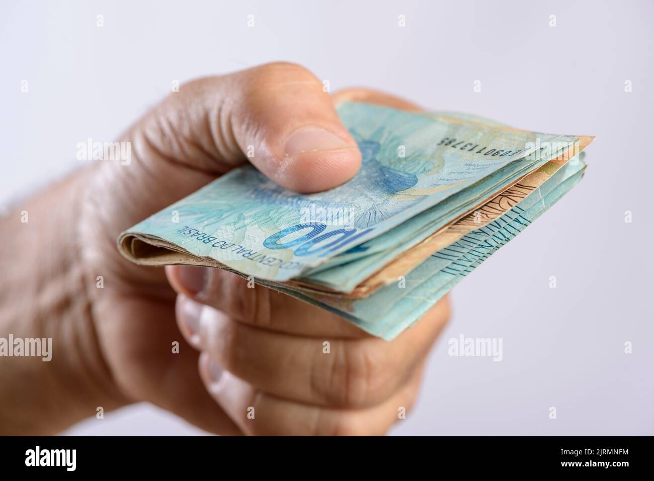 Hand holding money, six hundred reais, Brazilian currency, on white background. Stock Photo