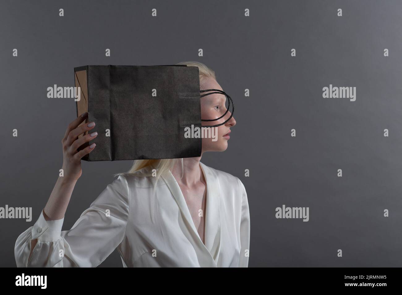 White caucasian albino blond woman holds shopping bag. Sale and discounts on market and Black Friday concept. Stock Photo