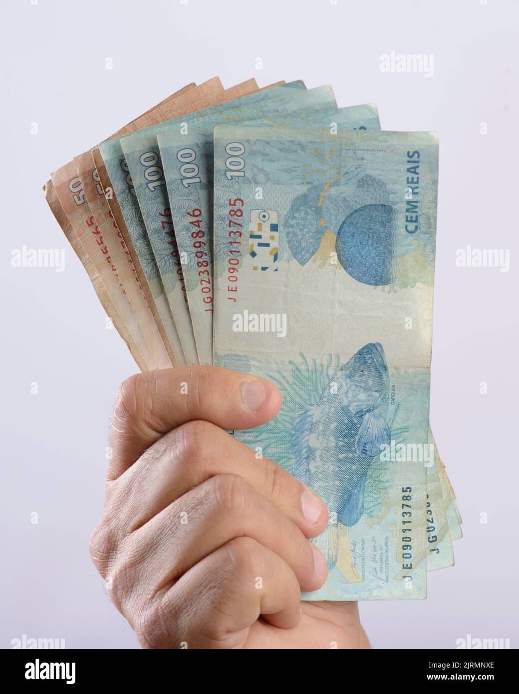 Hand holding money, six hundred reais, Brazilian currency, on white background. Stock Photo