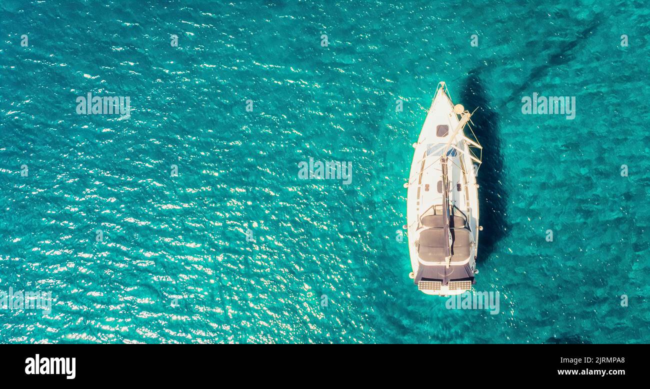 Boat sail floats near the shore. Luxury Lifestyle. Travel on sailboat at sea with clear water. Calm place Stock Photo