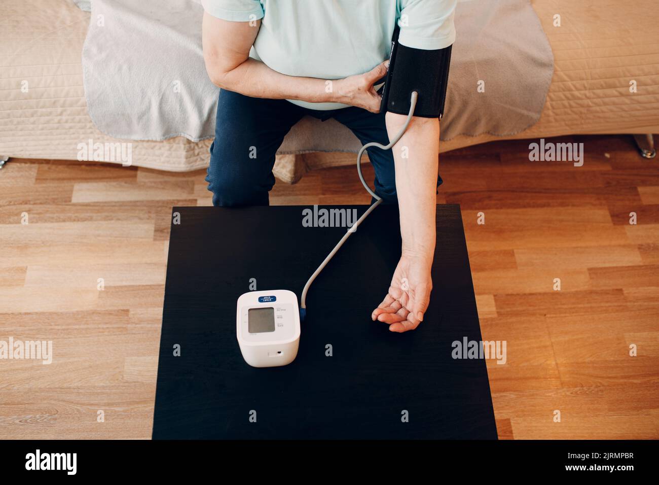 Senior woman taking measures blood pressure at home. Self care of