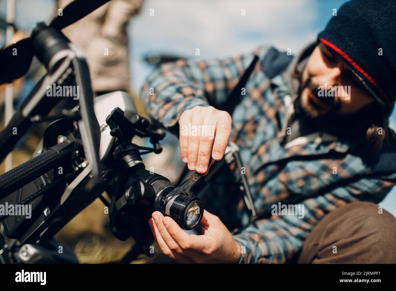 Man pilot checking quadcopter drone camera before aerial flight and filming Stock Photo