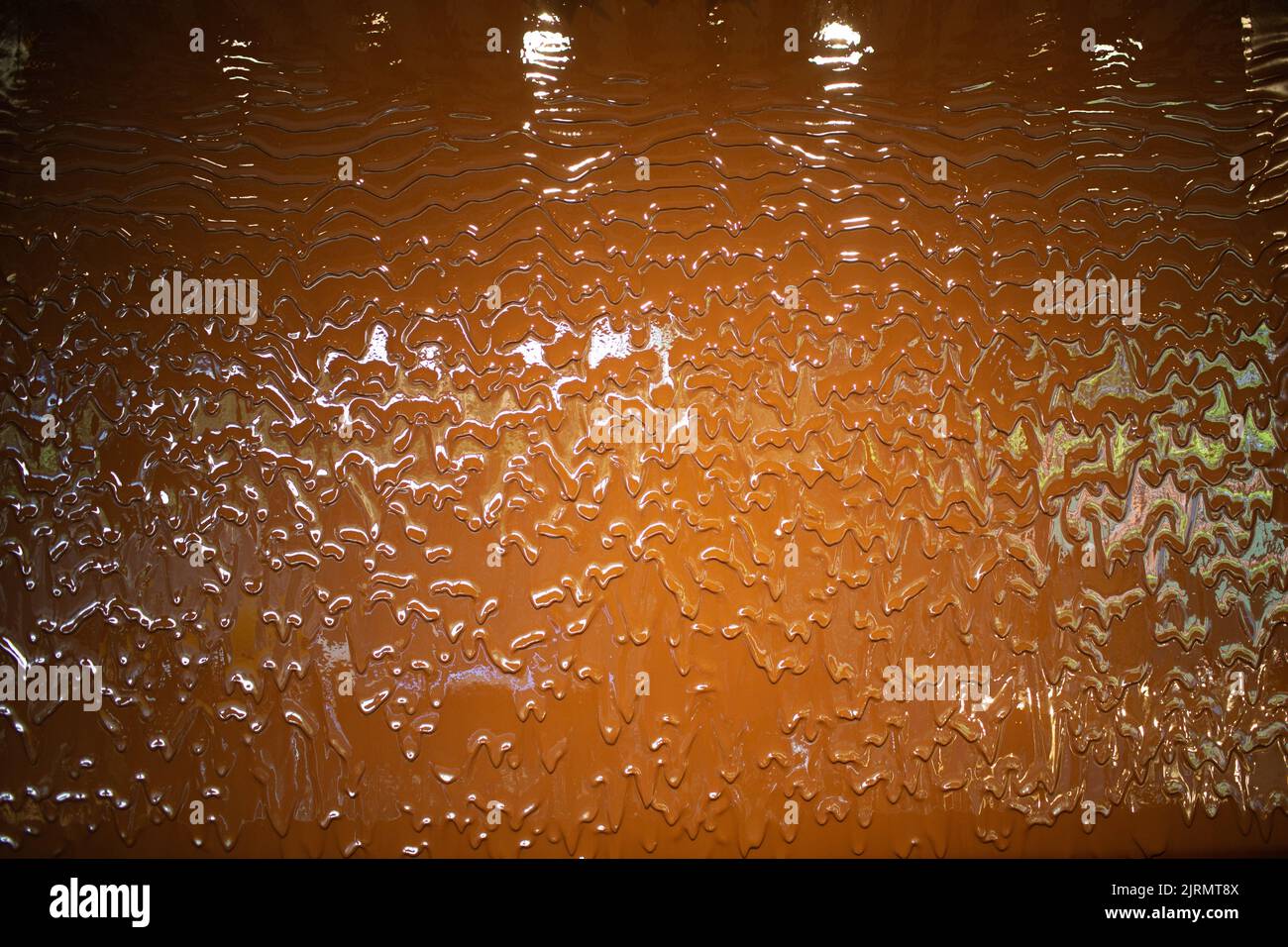 Liquid milk chocolate flowing wall with waves. Stock Photo