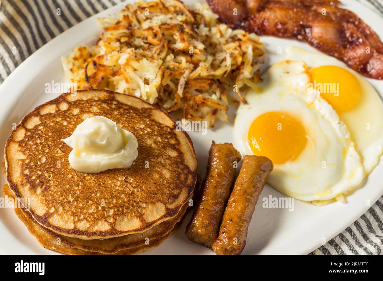 Full Homemade American Pancake Breakfast Brunch with Eggs Bacon and Hashbrowns Stock Photo