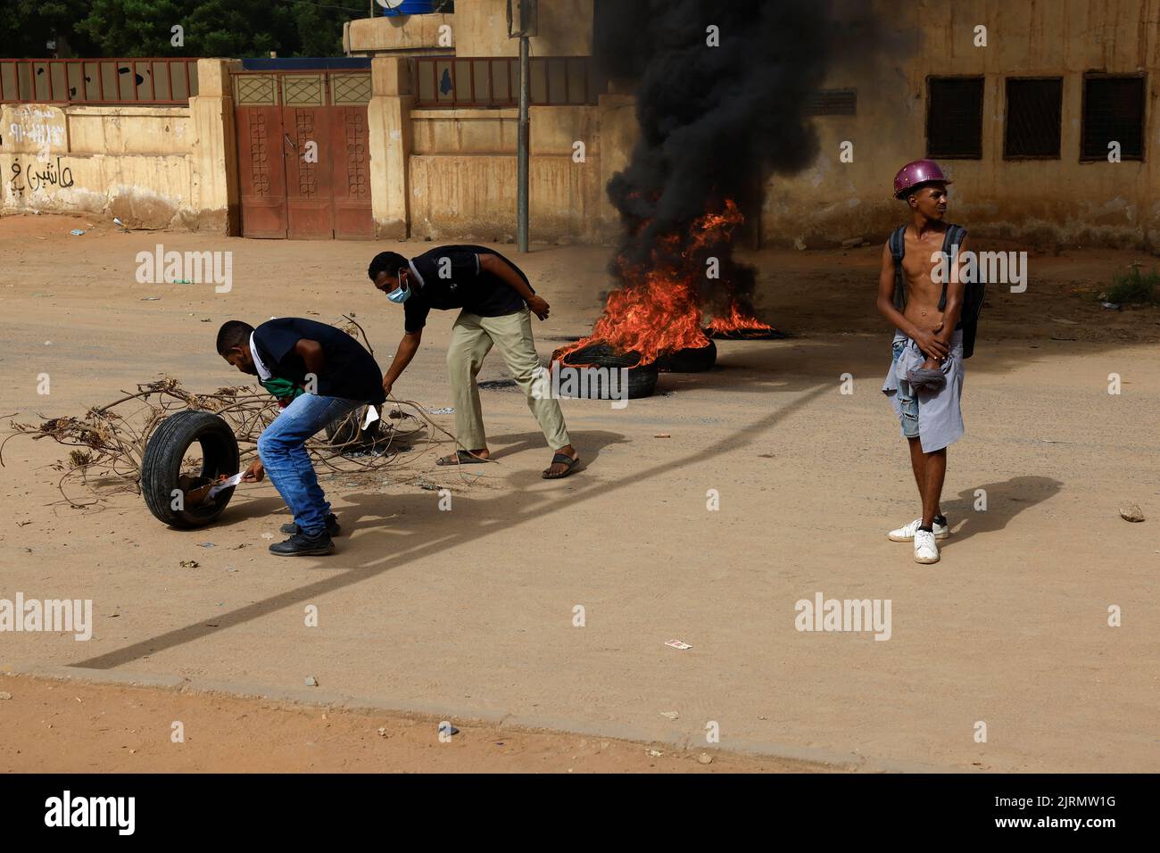 Demonstrators light tires for a fire barricade during at a rally against military rule following the last coup, in Khartoum, Sudan August 25, 2022. REUTERS/Mohamed Nureldin Abdallah Stock Photo