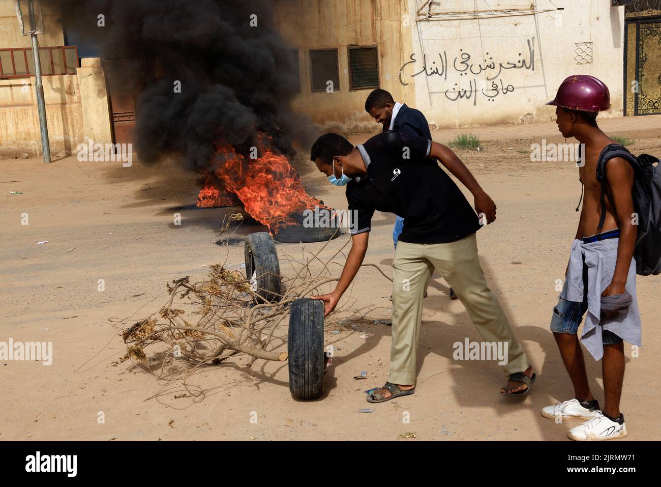 Demonstrators set up tires for a fire barricade during at a rally against military rule following the last coup, in Khartoum, Sudan August 25, 2022. REUTERS/Mohamed Nureldin Abdallah Stock Photo