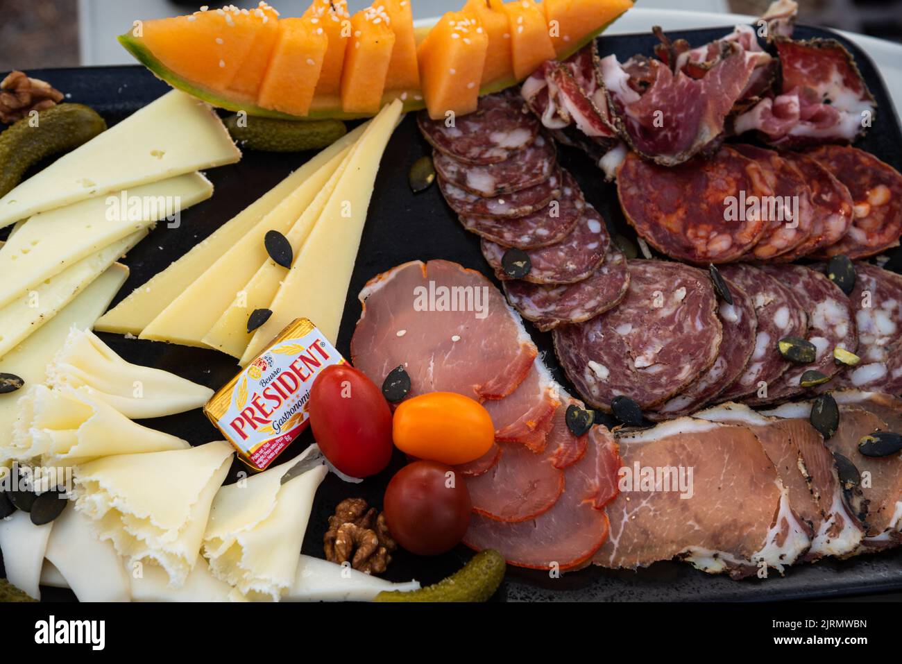 Salami and cheese plate served with President butter in traditional French bar.  President is a French dairy brand created in 1933 and worldwide famou Stock Photo