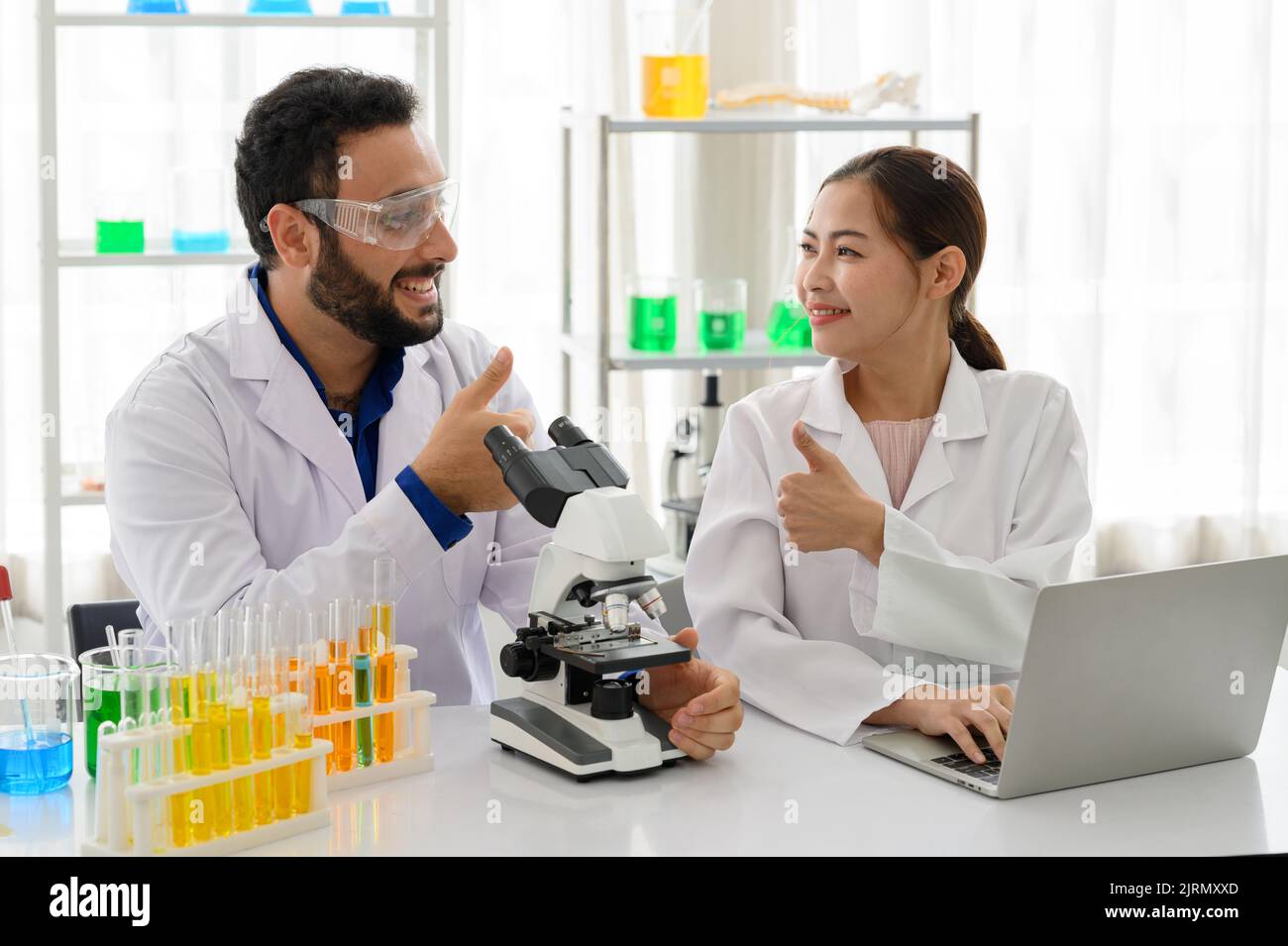 Two scientist laboratory smiling and thumb up doing excellent Stock Photo