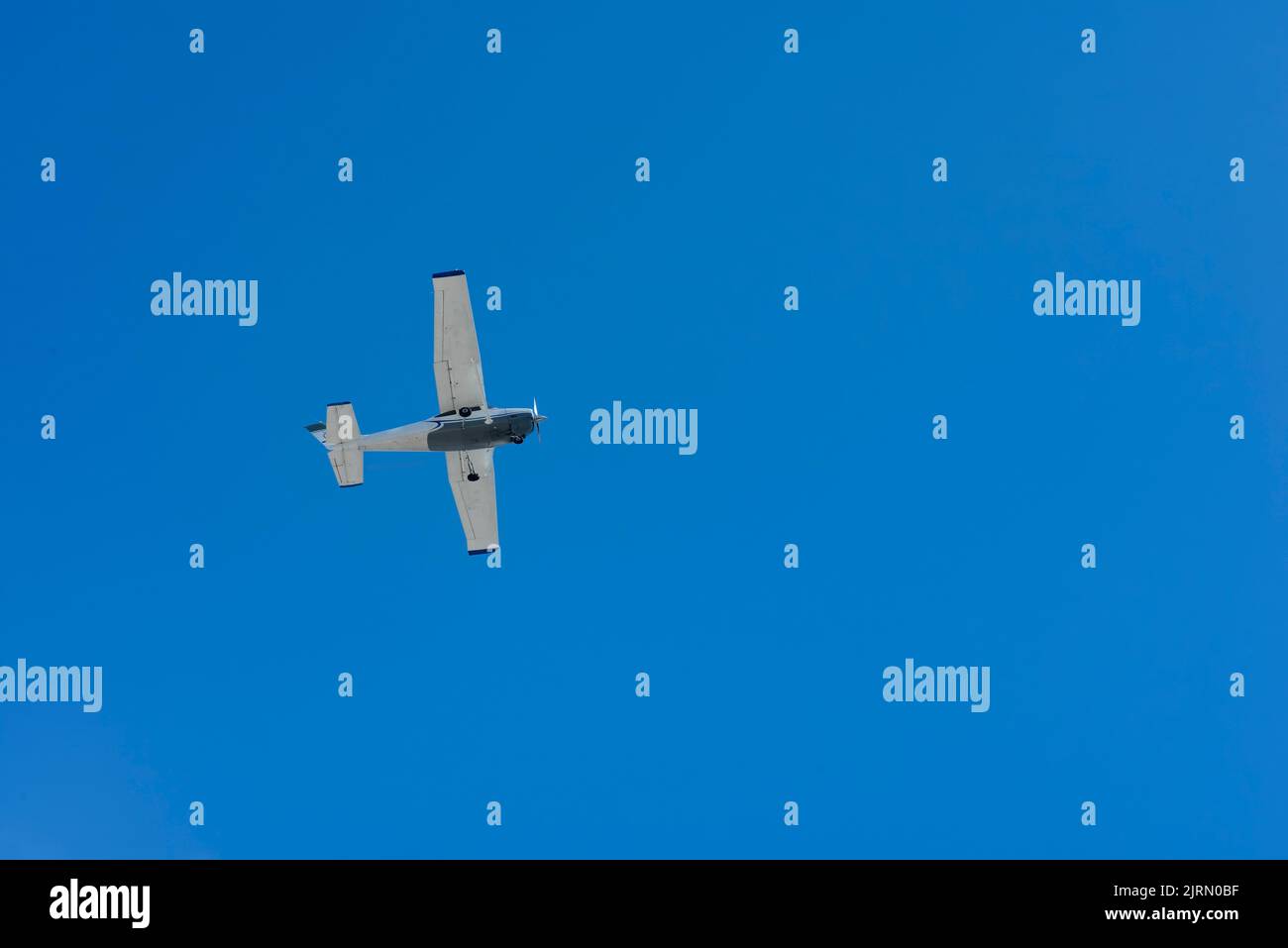 A small single-engine plane flying against the blue sky. on blue, Playa del Carmen, Mexico Stock Photo