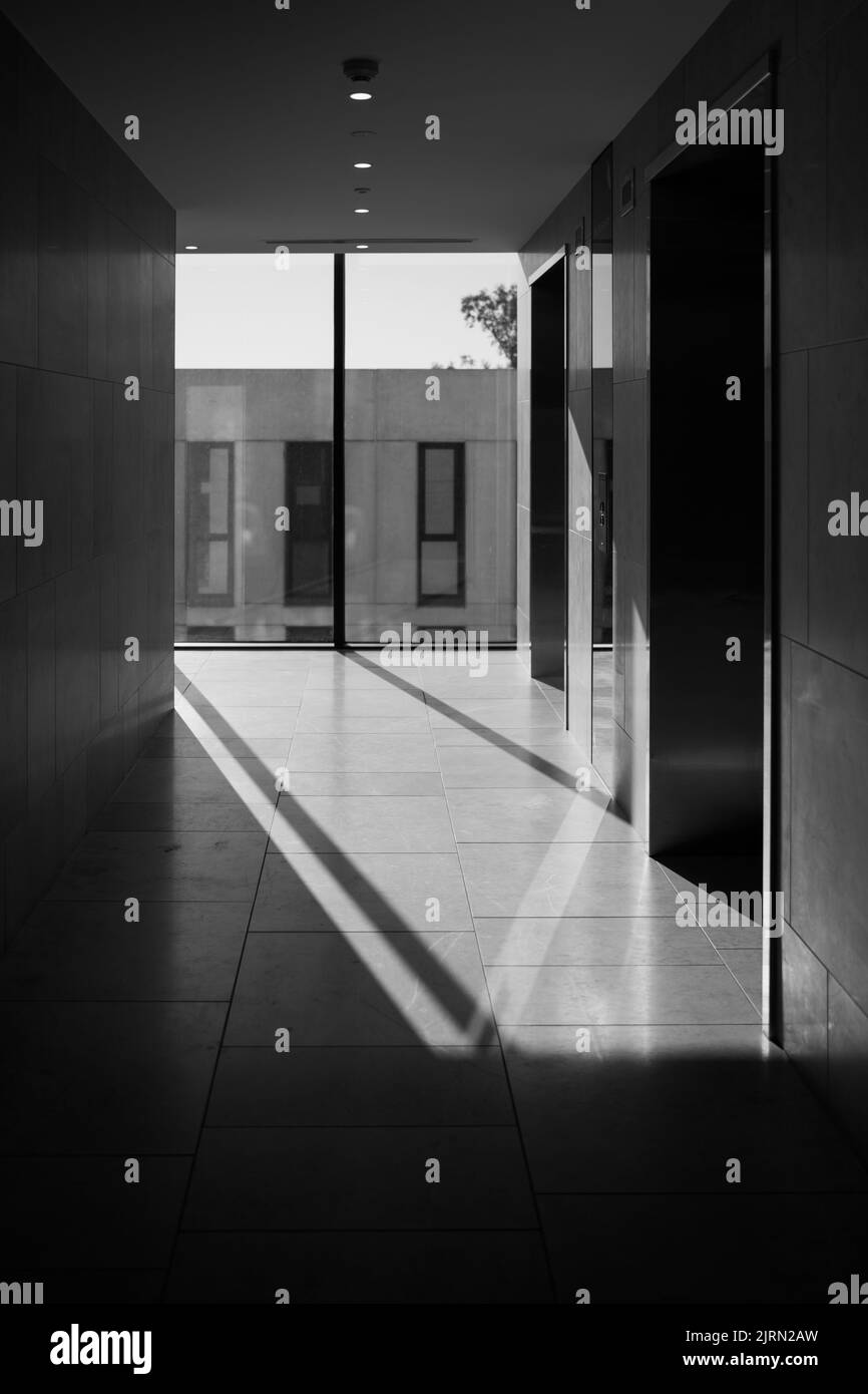 A vertical grayscale shot of the entrance of a modern building Stock ...