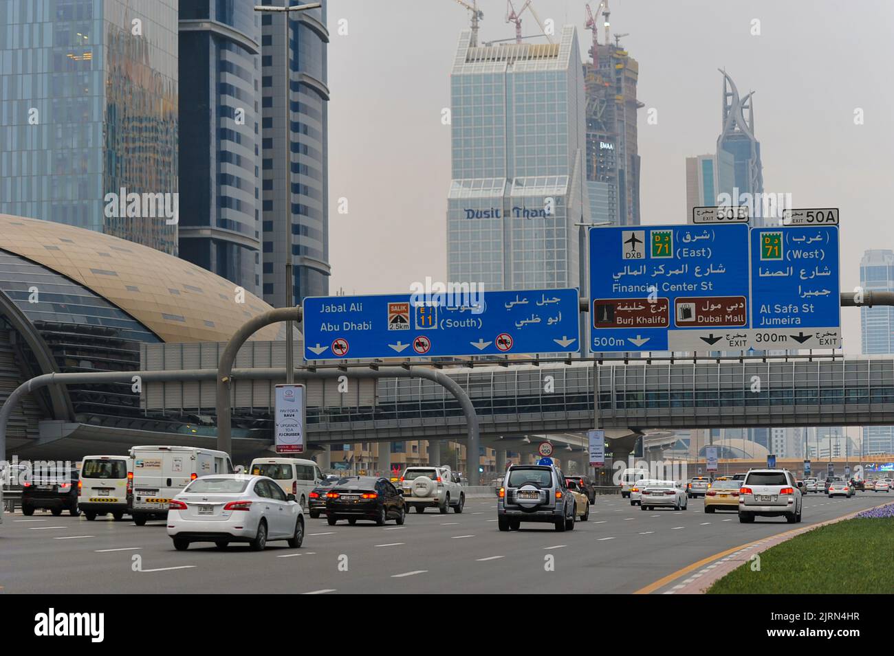 Dubai, United Arab Emirates: cars pass under a large road sign on Sheikh Zayed Road, the longest highway in all of the Emirates. Stock Photo