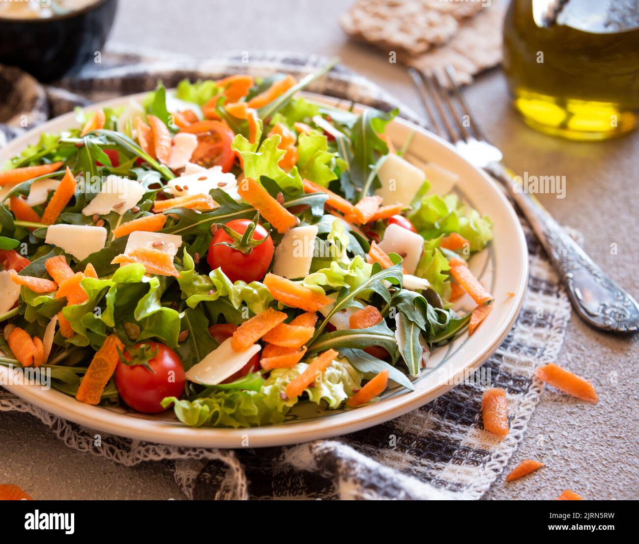 Fresh vegetables salad with tomatoes, arugola, parmesan cheese and other ingredients, healthy food Stock Photo