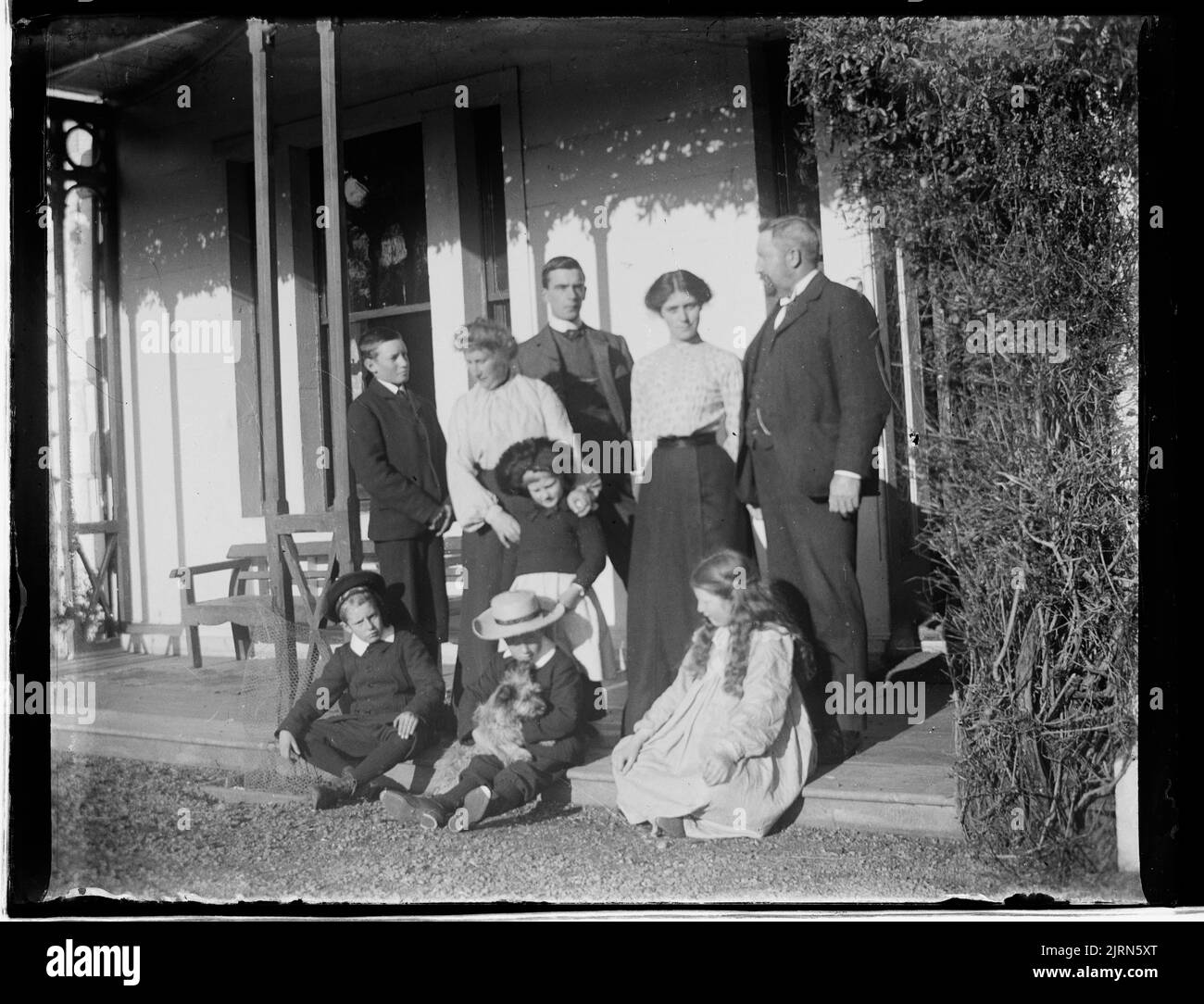 Family group on porch, circa 1910-1919, by Crombie and Permin. Stock Photo