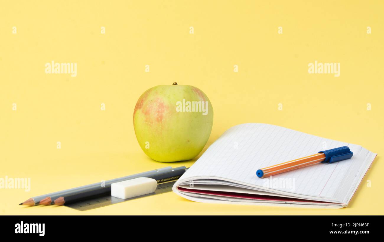 Workbook with pen and pencils for studying, apple for a snack Stock Photo