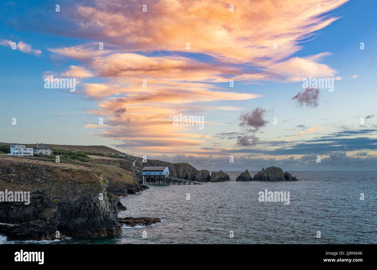 Mother Ivey's Bay, Cornwall, UK. 25th August 2022. UK Weather. Lenticular clouds at sunrise over the lifeboat station at Padstow. Credit Simon Maycock / Alamy Live News. Stock Photo