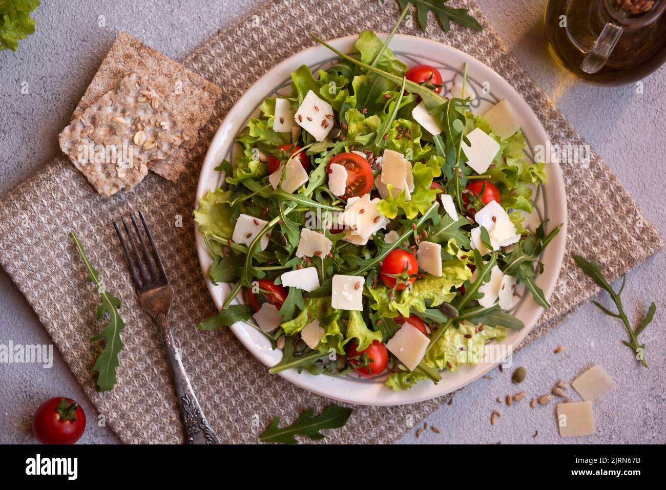Fresh vegetables salad with tomatoes, arugola, parmesan cheese and other ingredients, healthy food Stock Photo