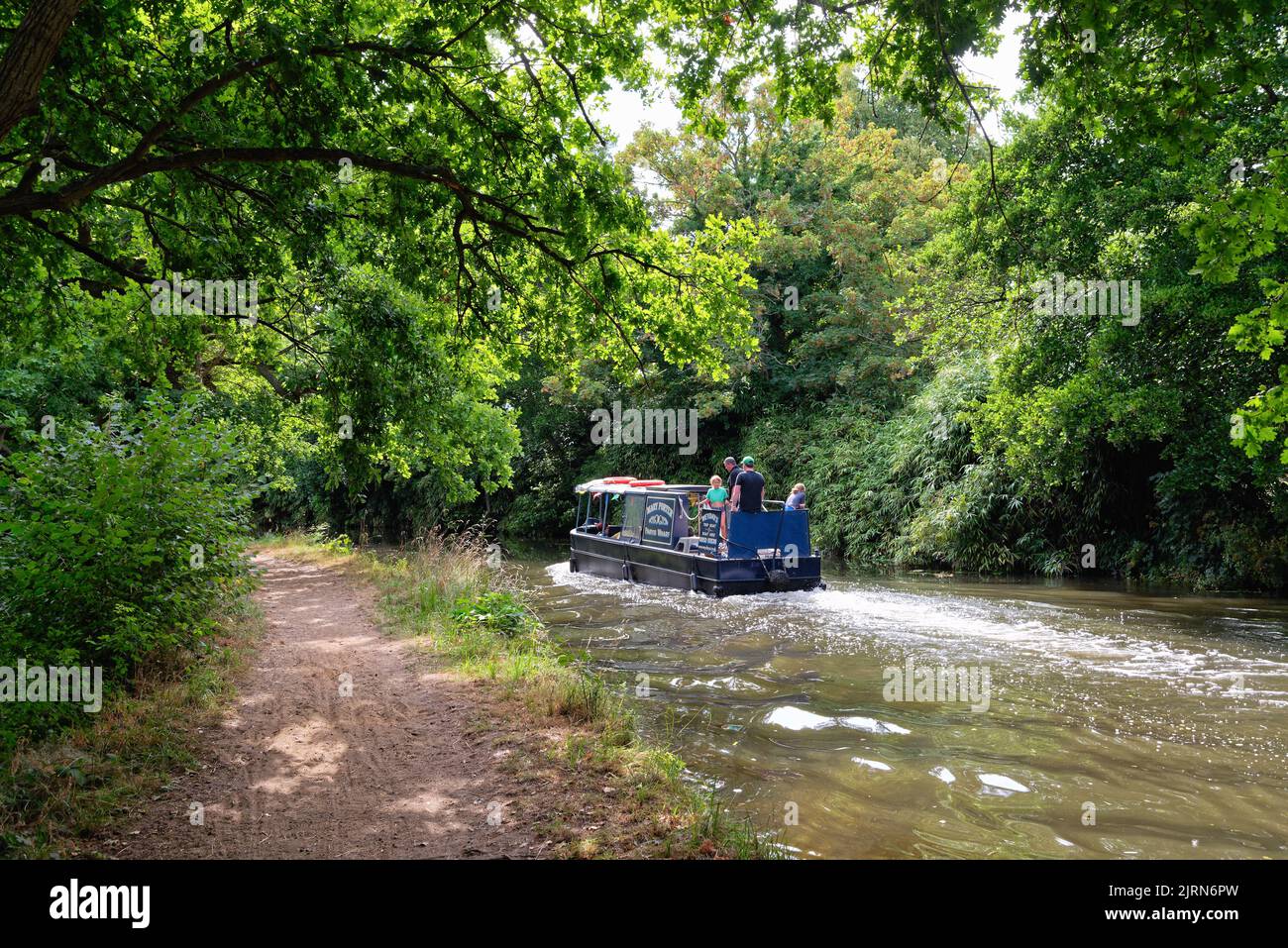 A narrow boat cruising on the River Wey navigation canal on a summers day, Byfleet Surrey England UK Stock Photo