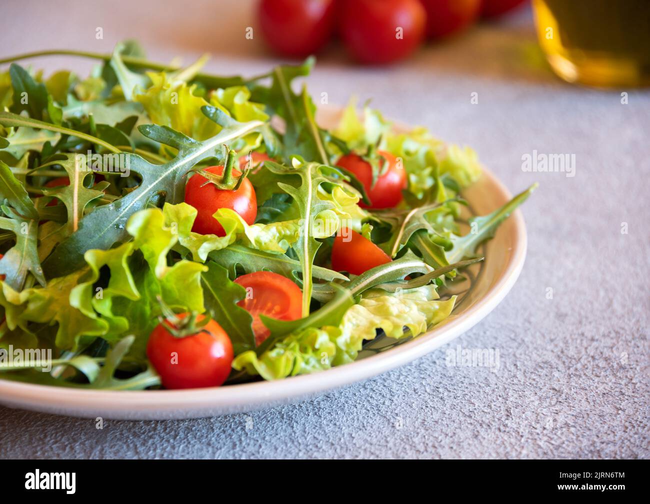 Fresh vegetables salad with tomatoes, arugola, lettuce and other ingredients, healthy food Stock Photo