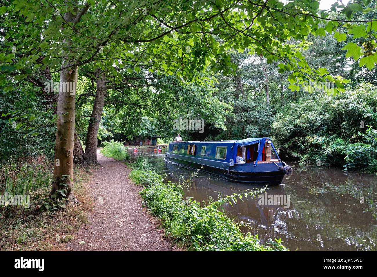 A narrow boat cruising on the River Wey navigation canal on a summers day, Byfleet Surrey England UK Stock Photo