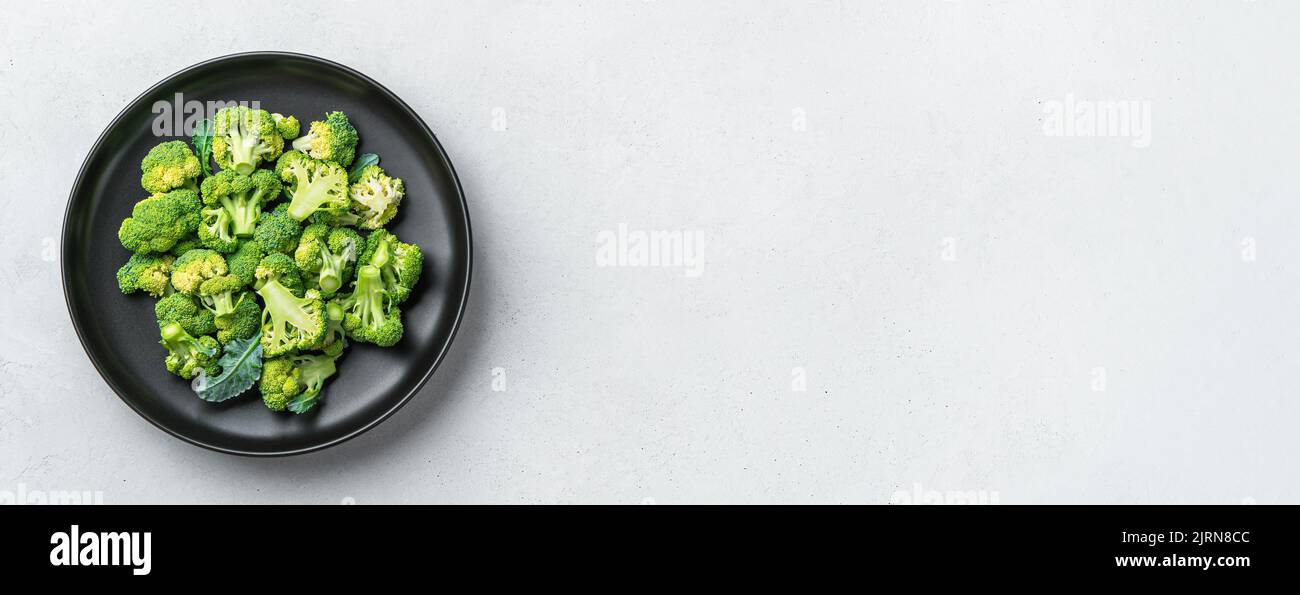 Broccoli in a black plate on a gray background. Stock Photo