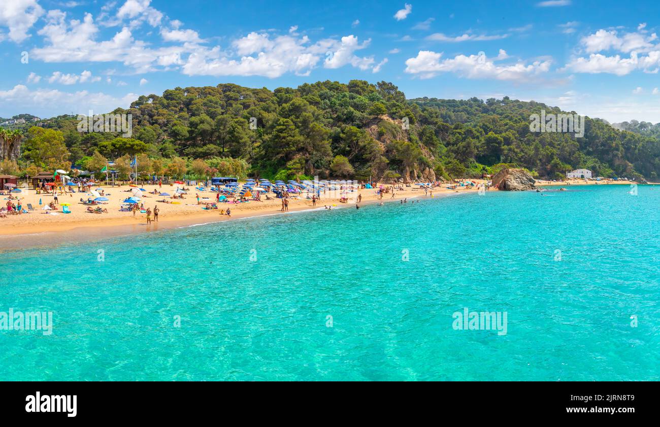 View from a boat of the clear turquoise sea along the Cala Santa Cristina sandy beach on the Costa Brava coast in Lloret de Mar, Spain. Stock Photo