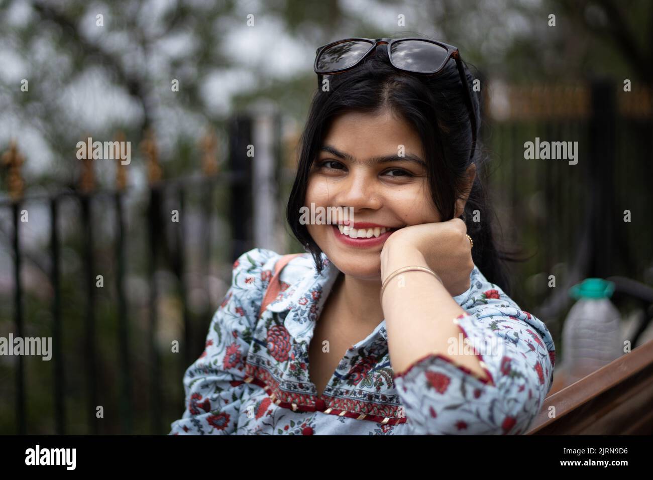 Portrait of a pretty Indian woman with sunglasses on head smiling and looking at camera Stock Photo