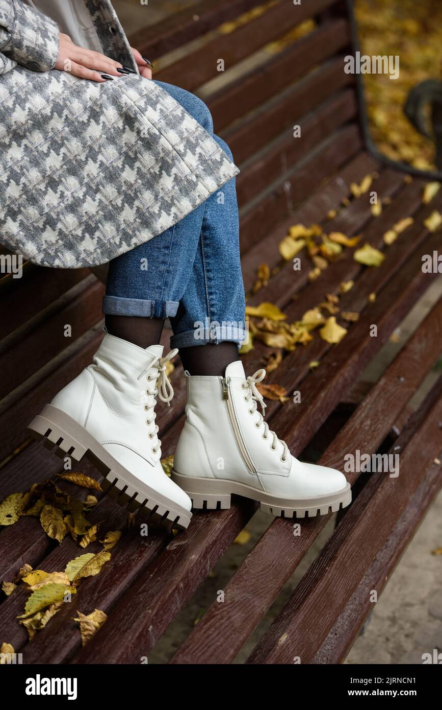 Female legs in a jeans and white fashion boots with laces Stock Photo