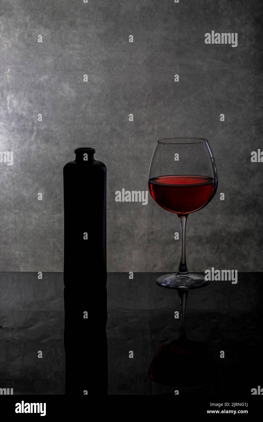 Still Life With Wine Glasses And A Bottle On A Reflective Surface Stock still-life-with-wine-glasses-and-a-bottle-on-a-reflective-surface-stock