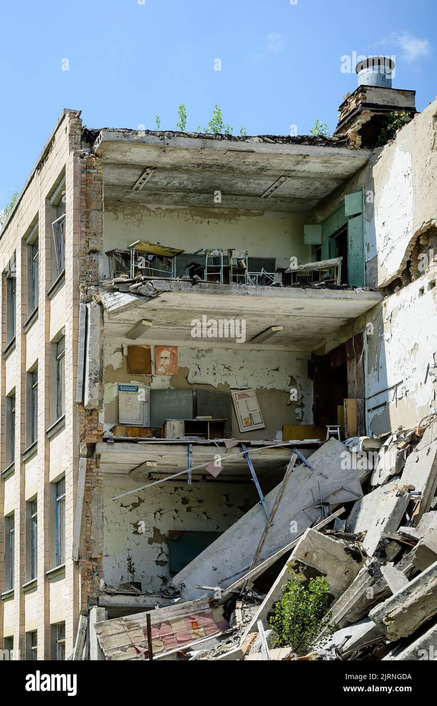 School building disintegrating in Prypiat, epicenter of the Chernobyl nuclear disaster in Ukraine. Collapsed side wall making the inner rooms visible Stock Photo