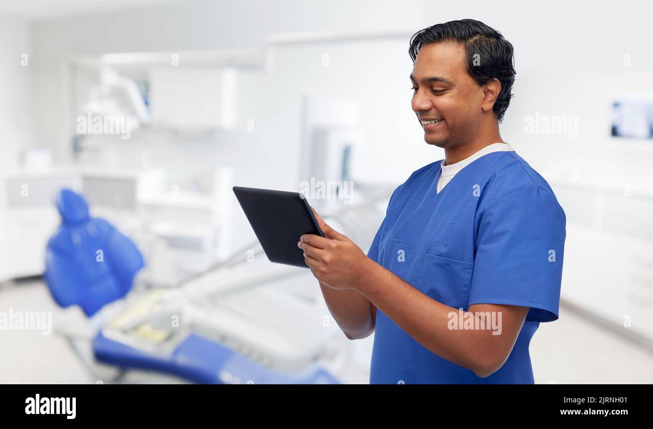 happy doctor or male dentist using tablet computer Stock Photo