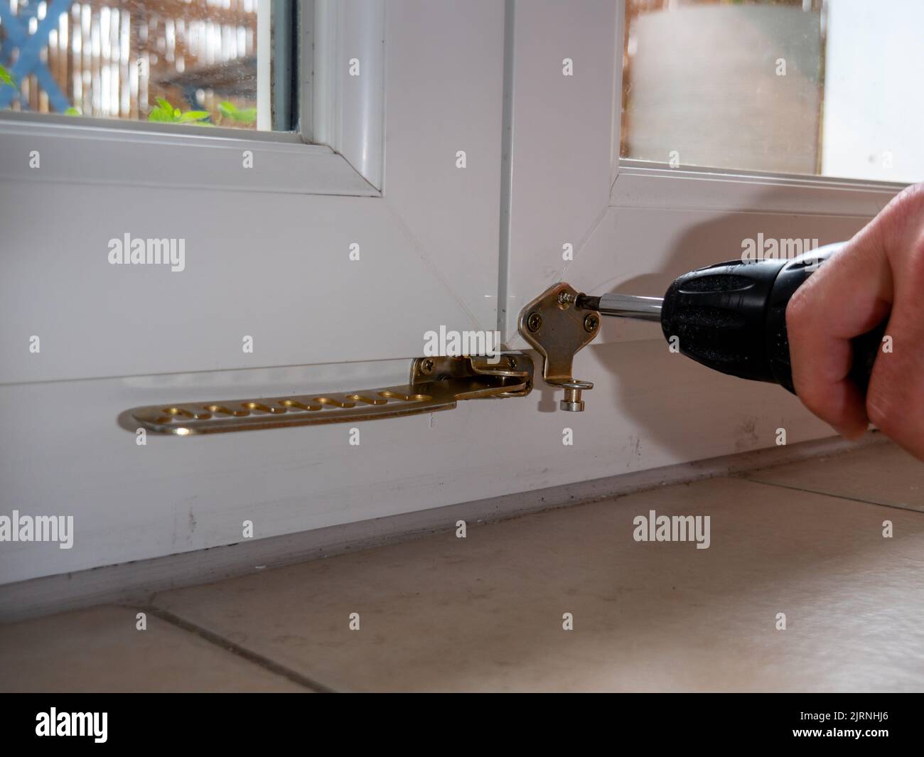 installation of a window stop, drilling holes for screws in plastic
