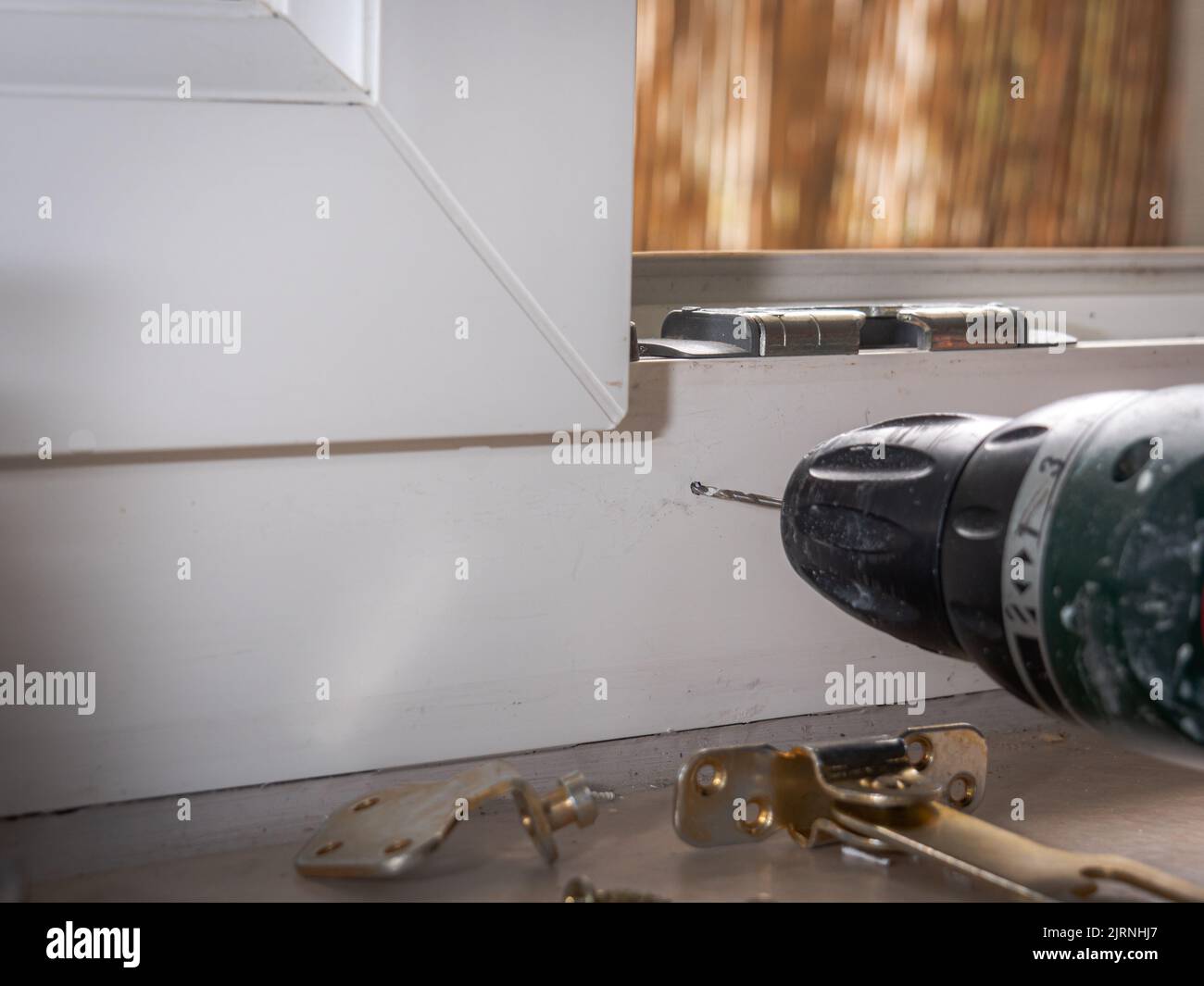 installation of a window stop, drilling holes for screws in plastic