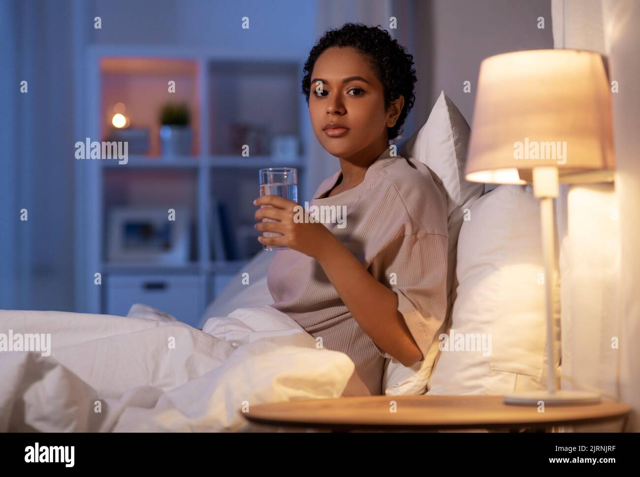 african american woman drinking water at night Stock Photo Alamy