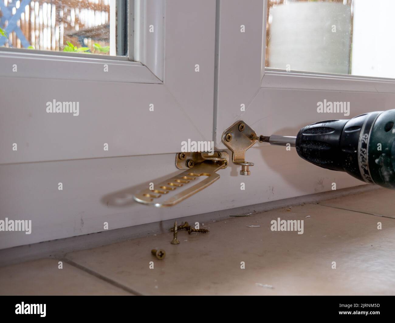 installation of a window stop, drilling holes for screws in plastic