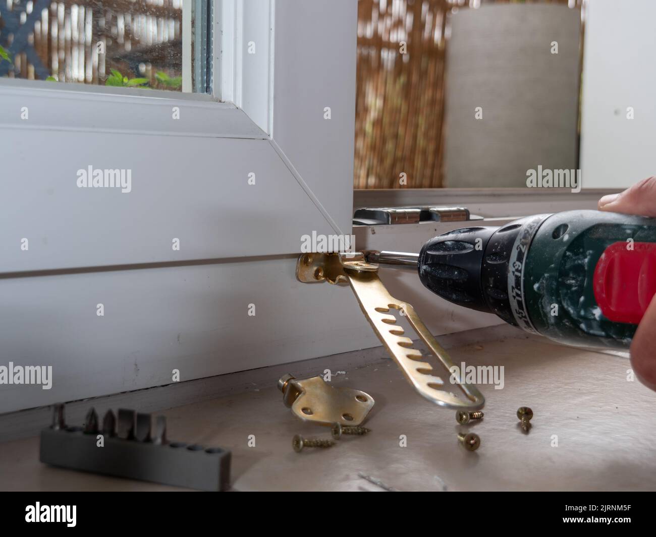 installation of a window stop, drilling holes for screws in plastic