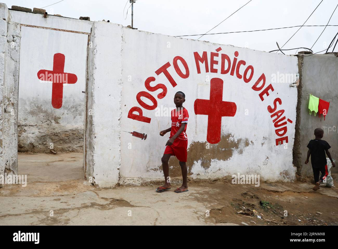 A boy walks past a clinic in Luanda, Angola, August 25, 2022. REUTERS/Siphiwe Sibeko Stock Photo