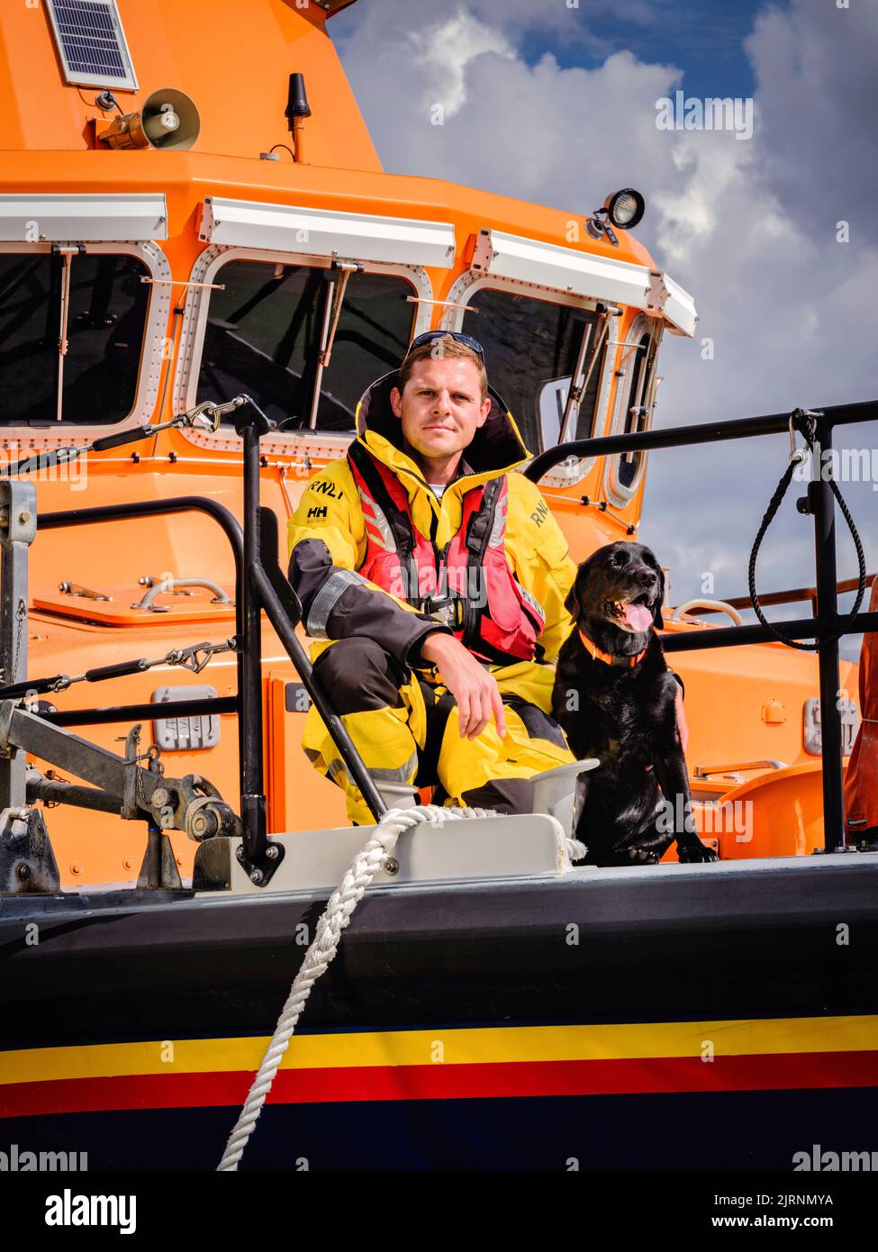 Editorial Use Only - Newhaven RNLI coxwain Lewis Arnold and his dog Oscar. Newhaven Lifeboat, East Sussex, UK. Picture by Jim Holden Stock Photo
