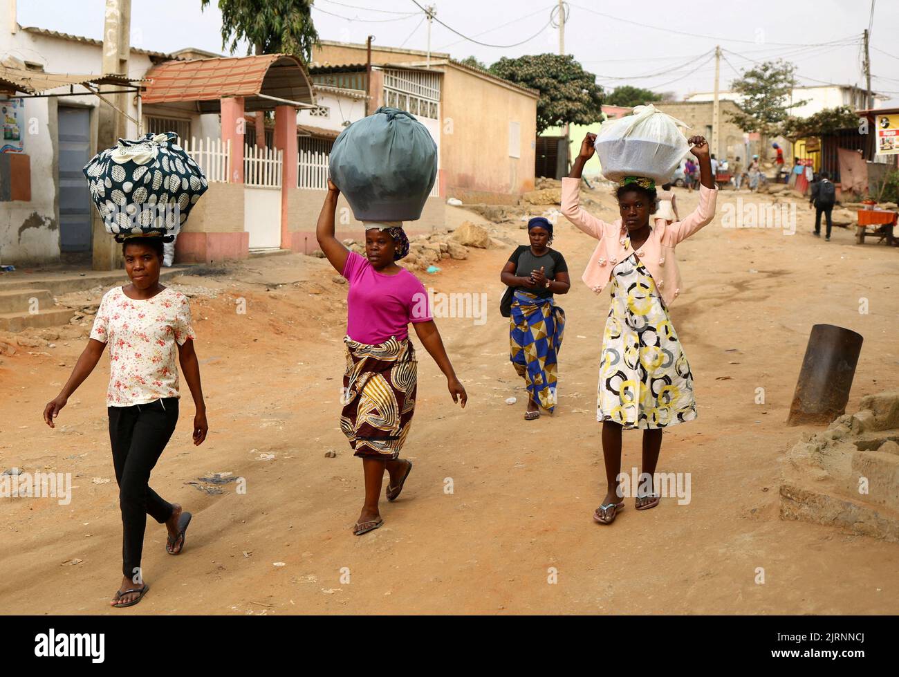 Women carrying their belongings walk in Luanda, Angola, August 25, 2022. REUTERS/Siphiwe Sibeko Stock Photo