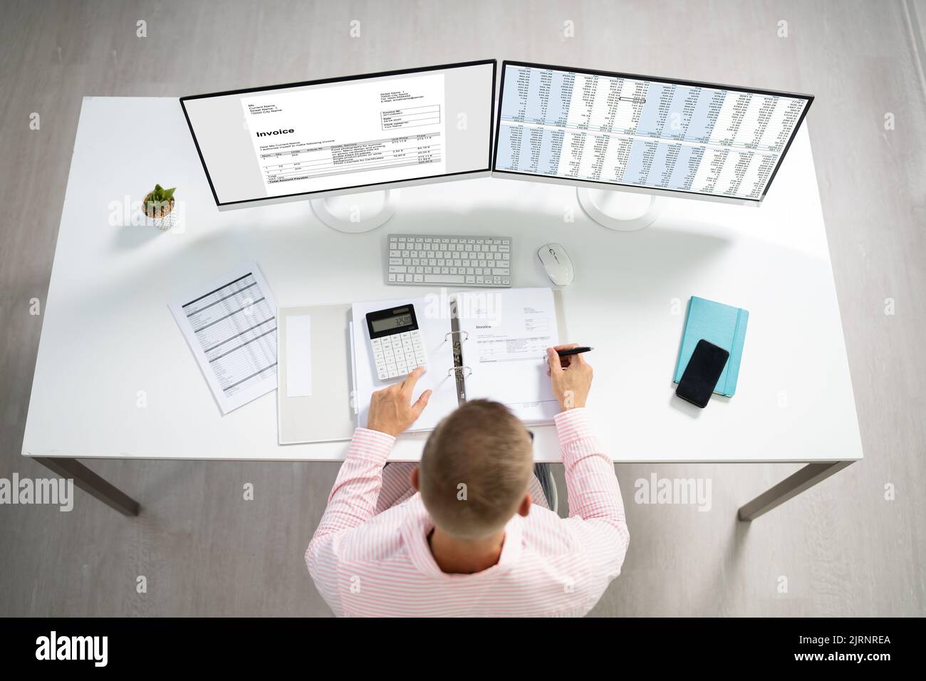 Young Businessman Calculating Invoice On Computer Screen Using Calculator Stock Photo