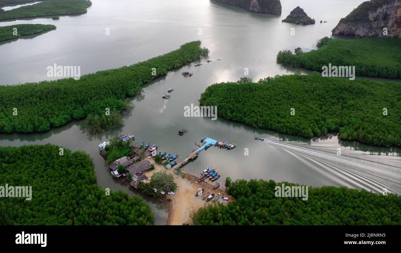 Aerial view of Thai traditional longtail fishing boats at the pier in Phang Nga Bay in the Andaman Sea, Thailand. Top view of many fishing boats float Stock Photo