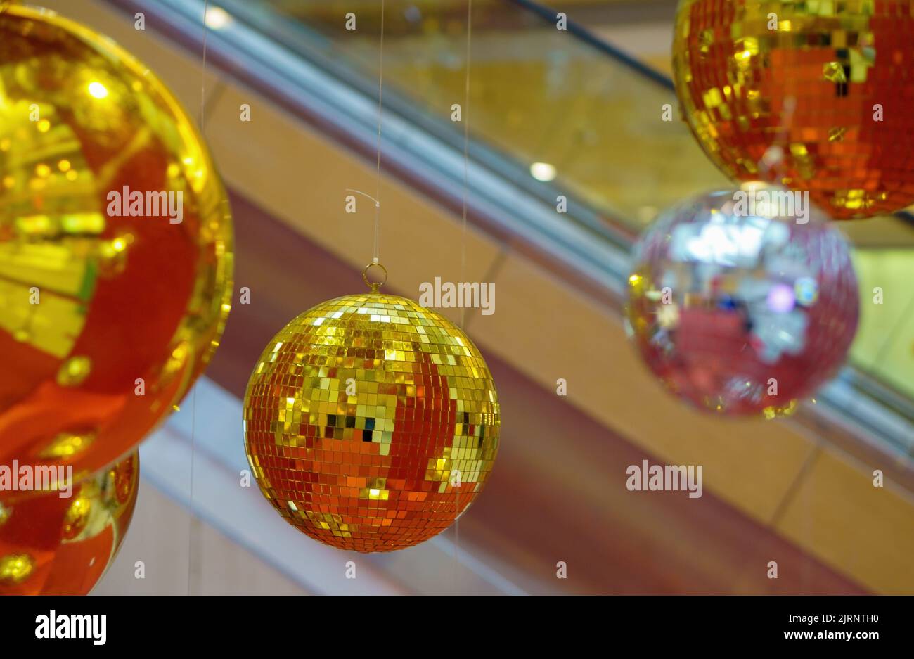 New year baubles. Shiny gold disco balls on mint background. Pop disco  style attributes, retro concept. Creative Christmas pattern. Flat lay, top  view. Stock Photo