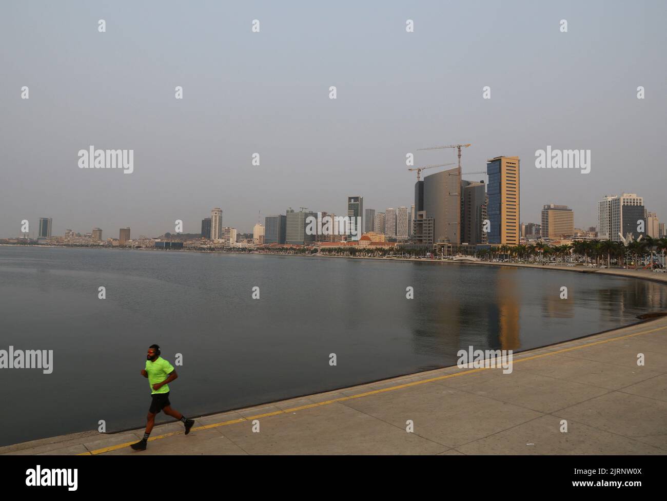 A jogger is seen with the general view of Luanda in Angola, August 25, 2022. REUTERS/Siphiwe Sibeko Stock Photo